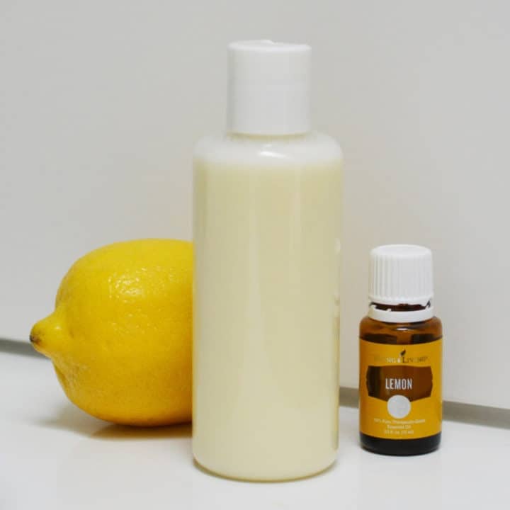 bottle of clarifying shampoo with whole lemon and bottle of lemon essential oil