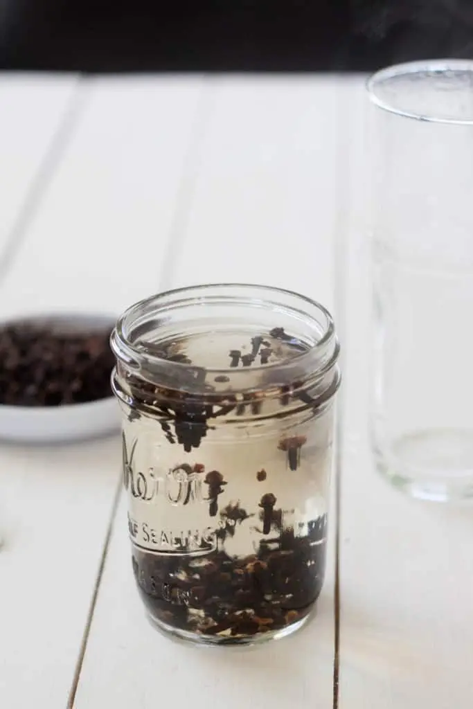 mason jar of whole cloves steeping in water