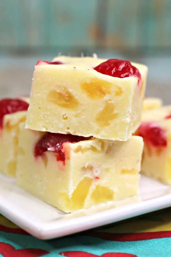 pieces of pineapple fudge stacked on white plate