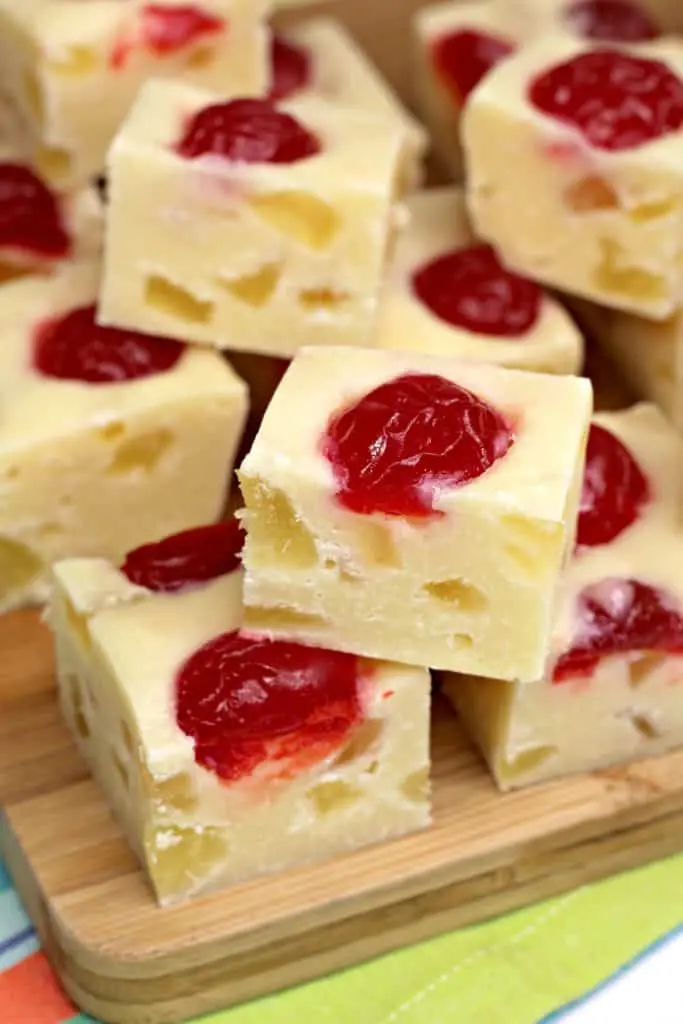 pieces of pineapple fudge stacked on bamboo cutting board