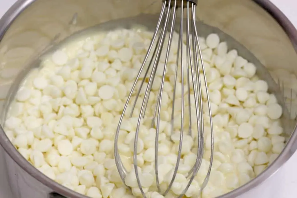 whisk stirring melted white chocolate chips, cake mix and sweetened condensed milk