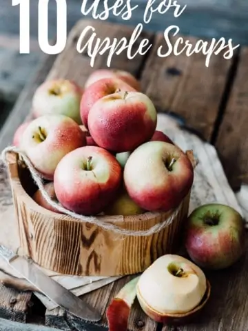 bucket of apples on a wooden cutting board with a knife