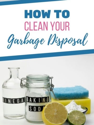 jars of vinegar and baking soda on a counter with a sponge and lemon cut in half