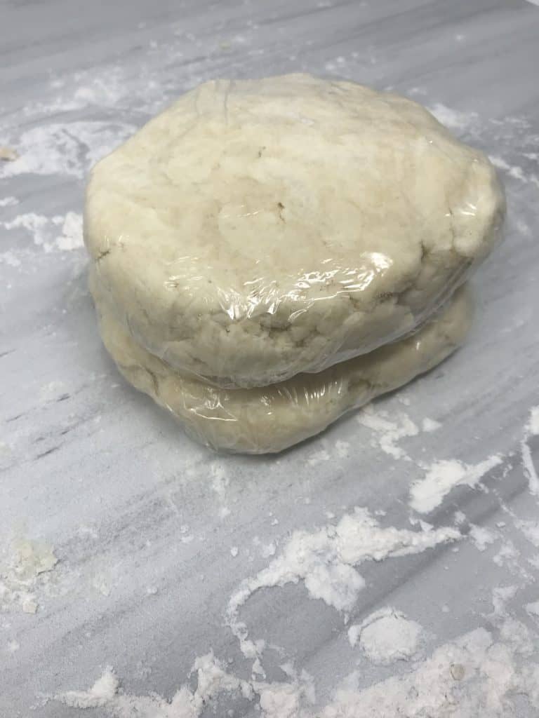 cream cheese dough wrapped in plastic wrap on marble counter
