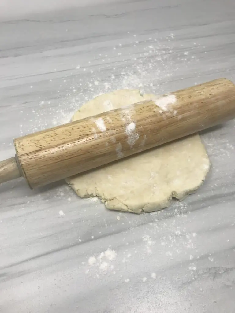 cream cheese dough on marble counter with rolling pin