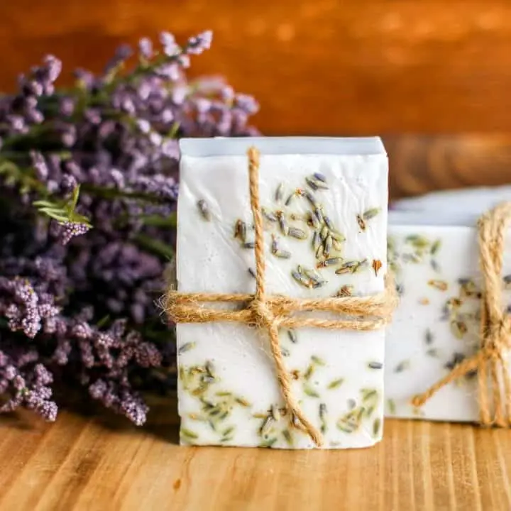 bar of lavendar soap tied with jute twine on cutting board with fresh lavendar