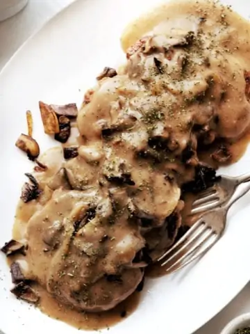 chicken salisbury steak patties on white platter with gravy