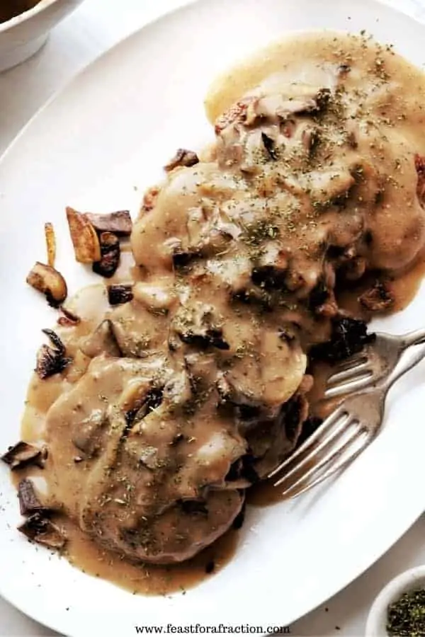 chicken salisbury steak patties on white platter with gravy