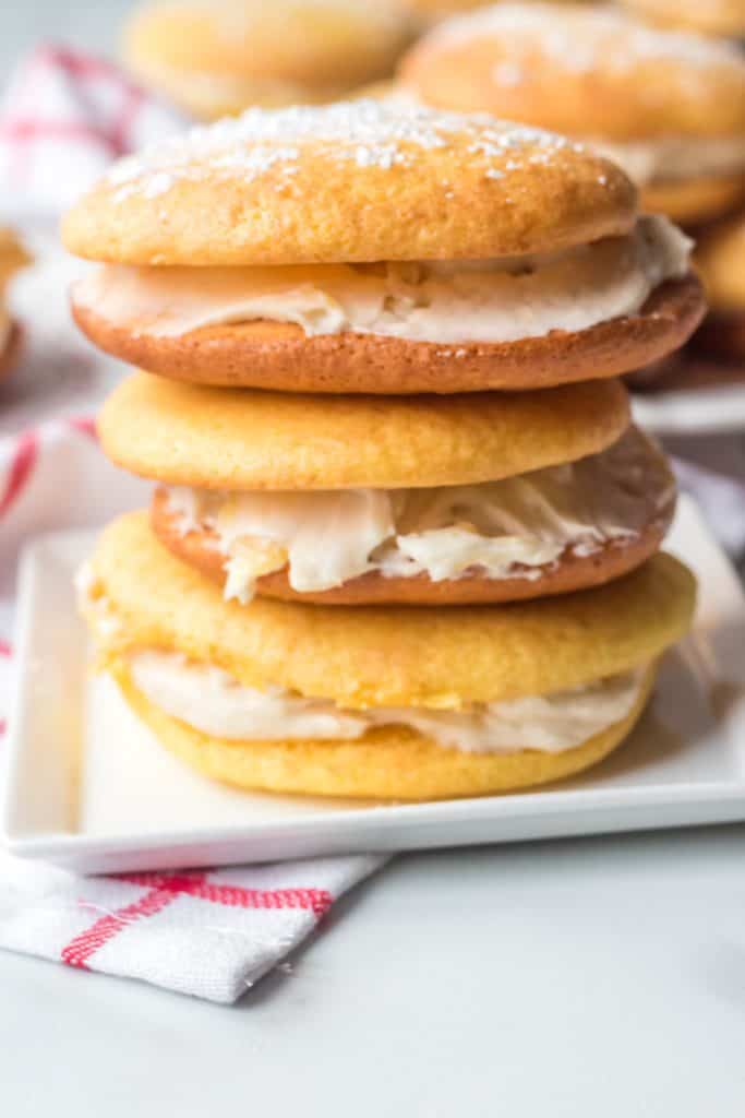 whoopie pies stacked on white square plate with white and red towel