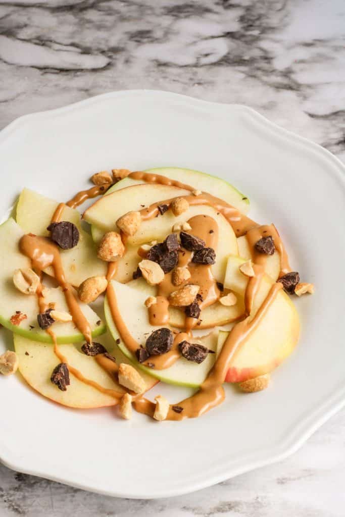 apple nachos on white plate on marble counter