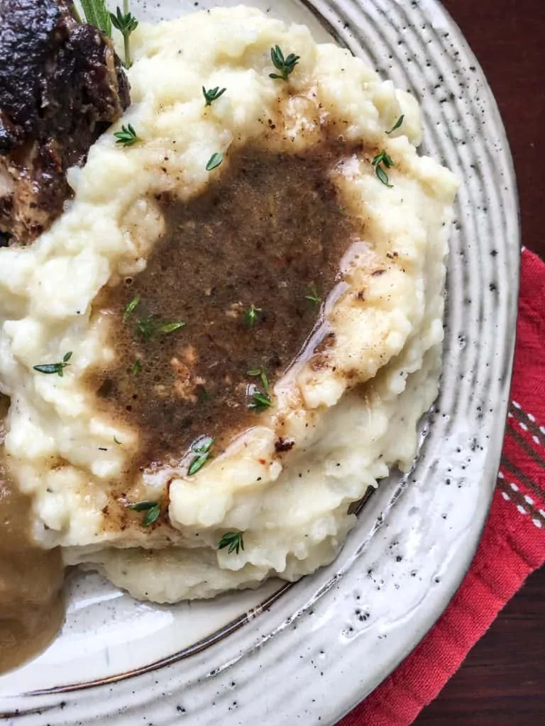 overhead instant pot mashed potatoes on grey plate with brown gravy