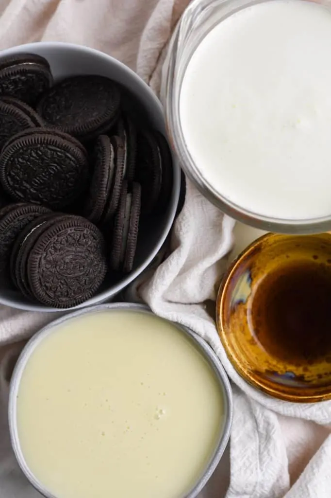 ingredients for no churn cookies and cream ice cream: oreo cookies, heavy whipping cream, vanilla, and sweetened condensed milk