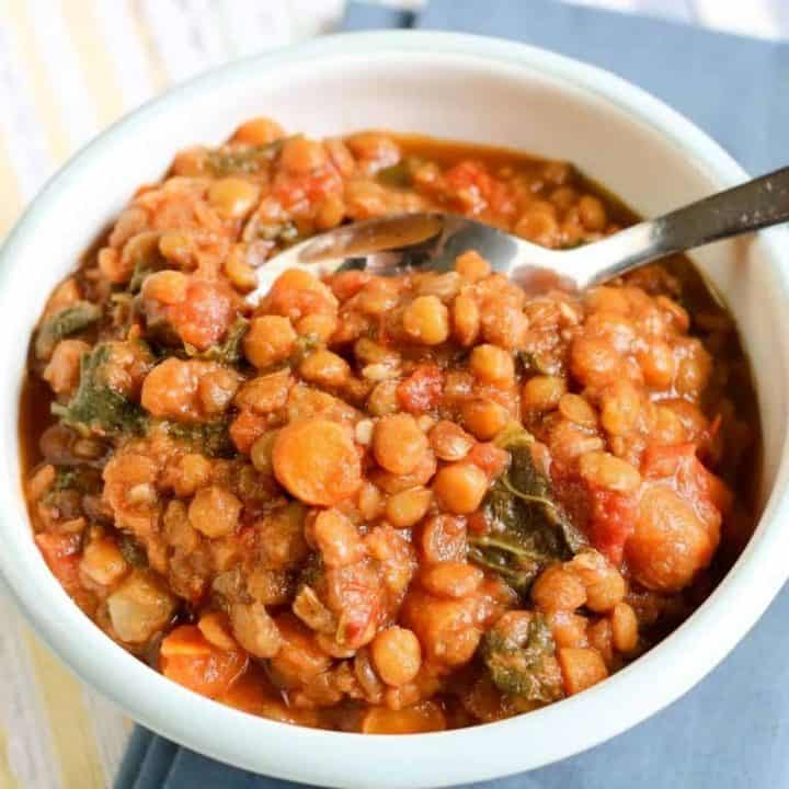 lentil soup in white bowl with blue napktin