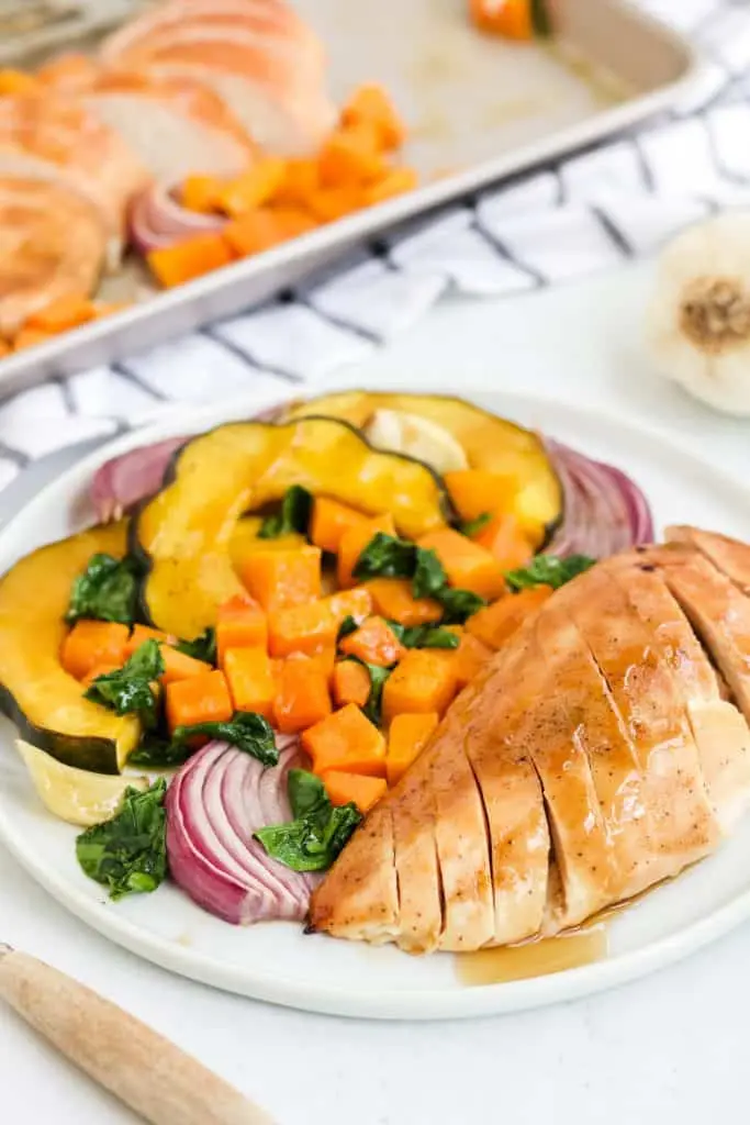 sliced chicken breast and roasted vegetables on white plate