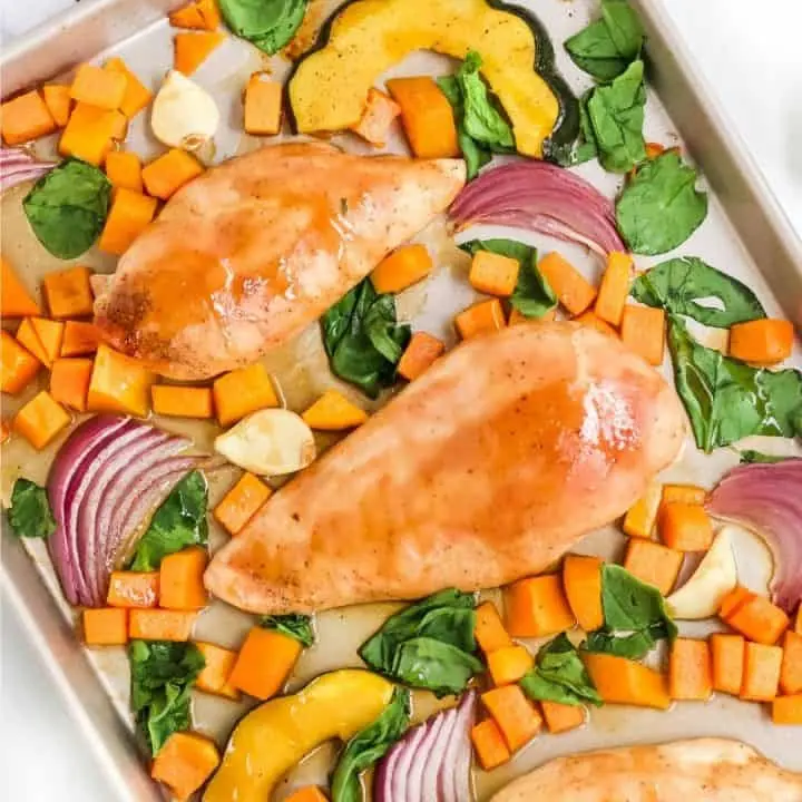 roasted chicken breast and winter squash on metal sheet pan