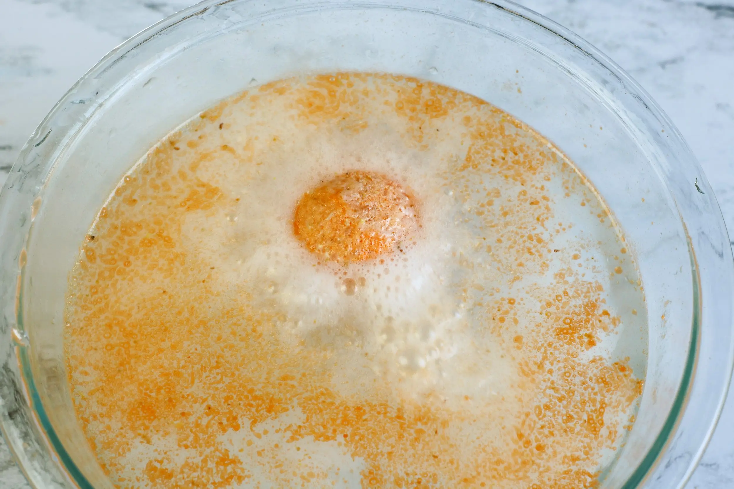 diy bath bomb dissolving in bowl of water