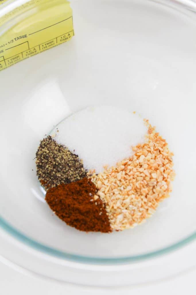 salt, pepper, dried garlic, dried onion, and chili powder in glass bowl