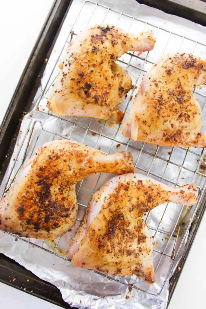 baked chicken leg quarters on baking sheet