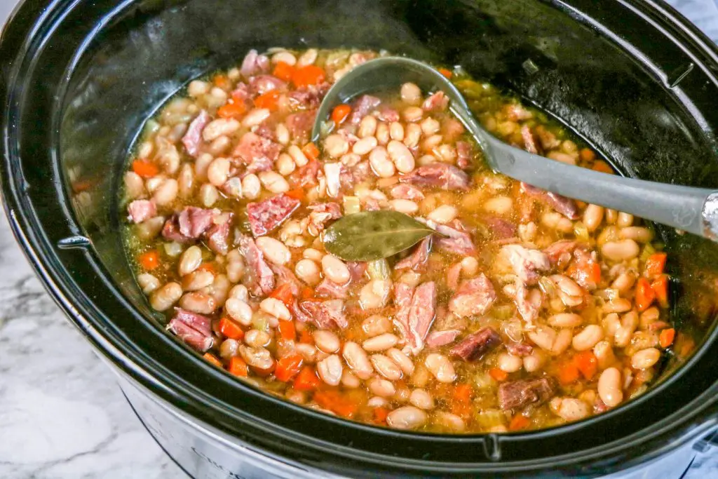 ham and bean soup in crock pot with ladle