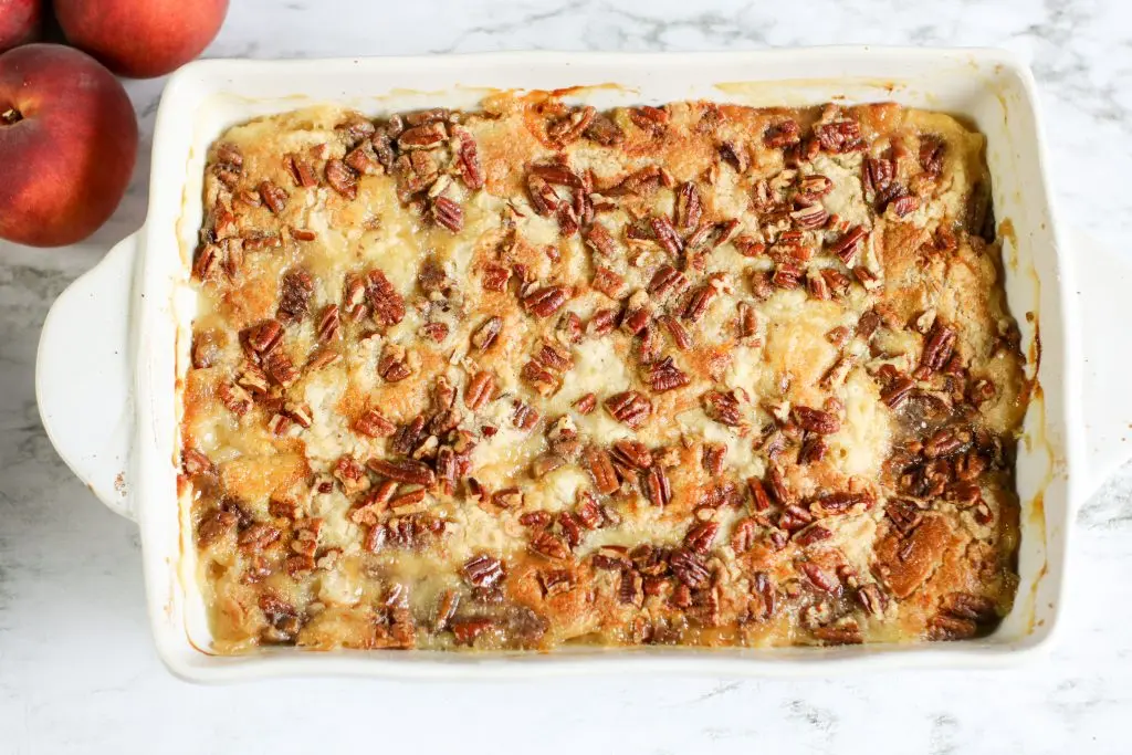 Overhead image of white chocolate peach dump cake with whole peaches