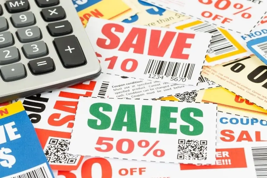 stack of coupons and calculator for extreme budgeting