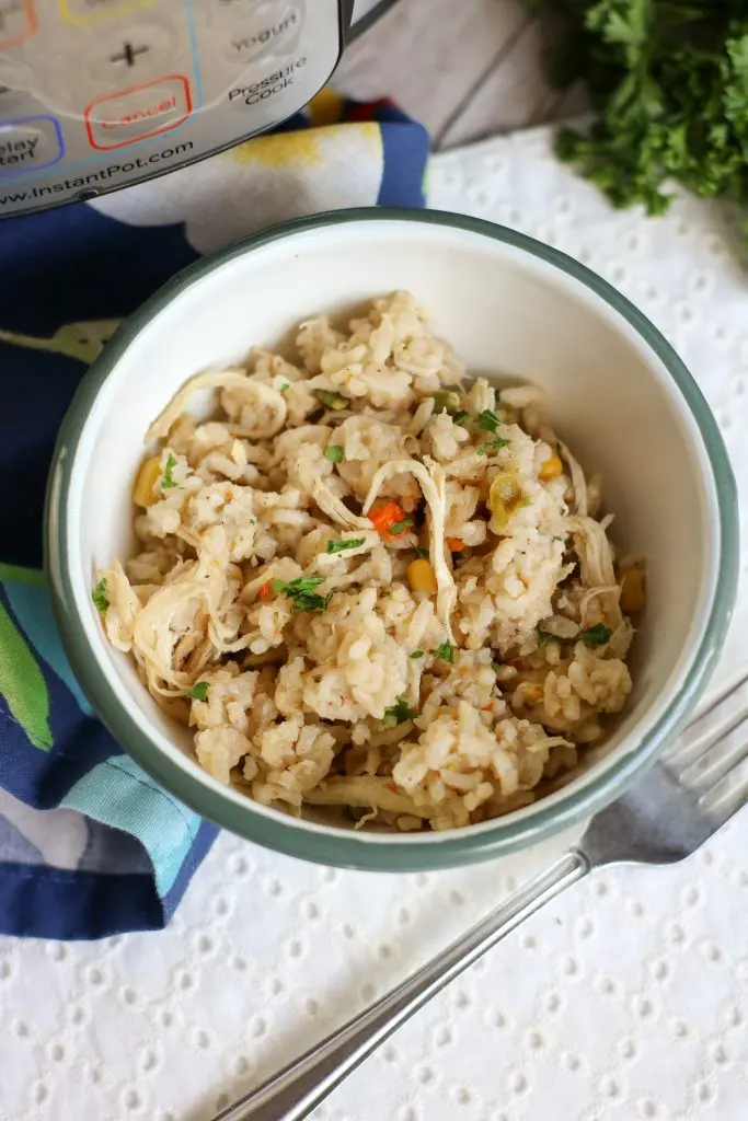 instant pot chicken and rice in white bowl with instant pot in background