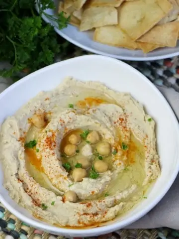 instant pot hummus in white bowl with bowl of pita chips
