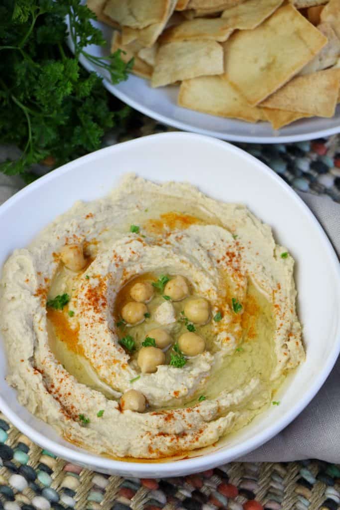 instant pot hummus in white bowl with bowl of pita chips