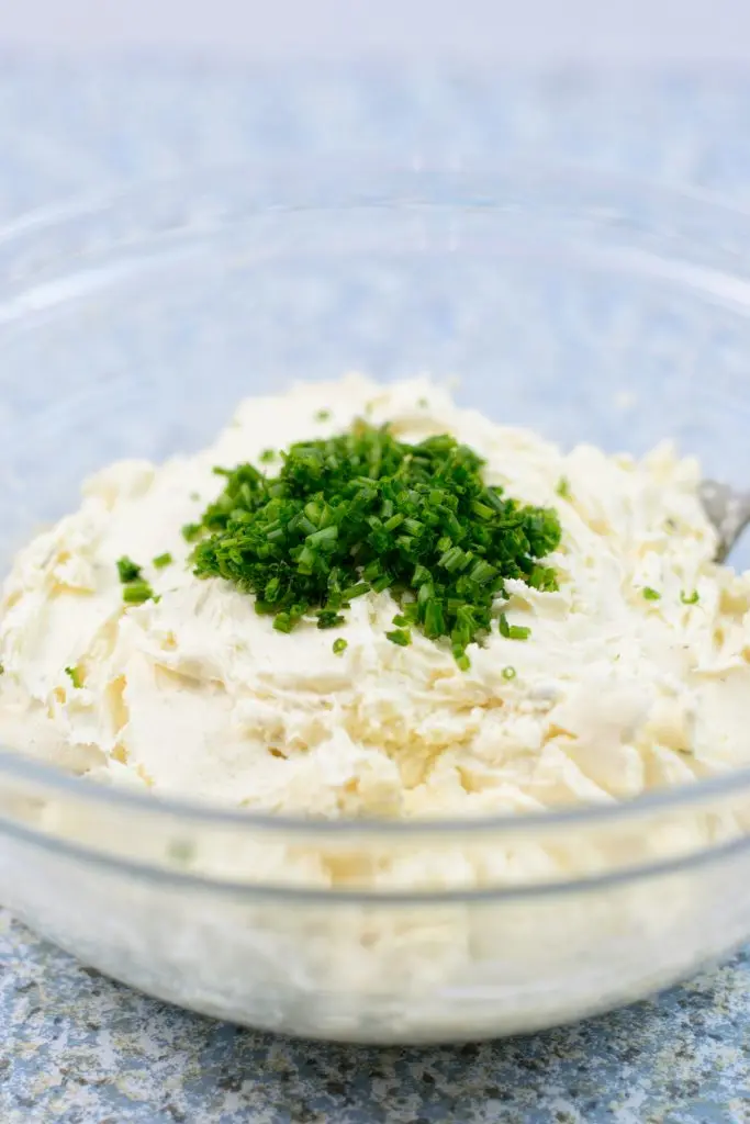 cream cheese and chopped chives in glass bowl