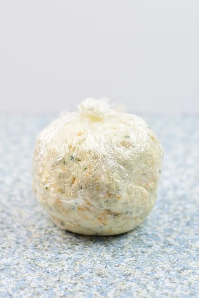 cheese ball wrapped in plastic wrap