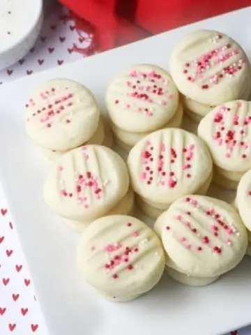 whipped shortbread cookies on square white plate with red napkin