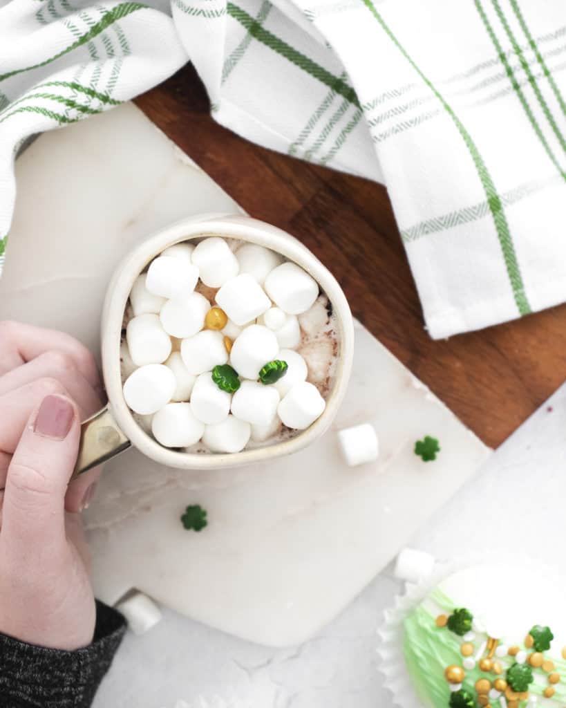 overhead view of peppermint hot cocoa in mug with marshmallows and shamrock sprinkles