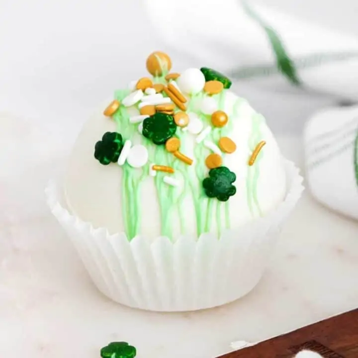 peppermint hot chocolate bomb with shamrock sprinkles in white cupcake liner