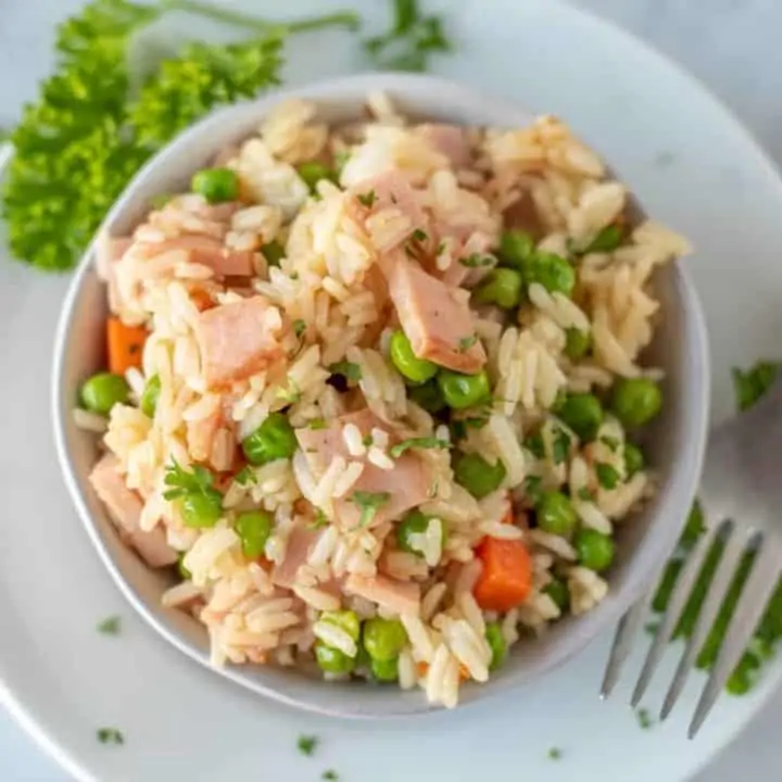 overhead view of teriyaki ham stir fry in white bowl with fork