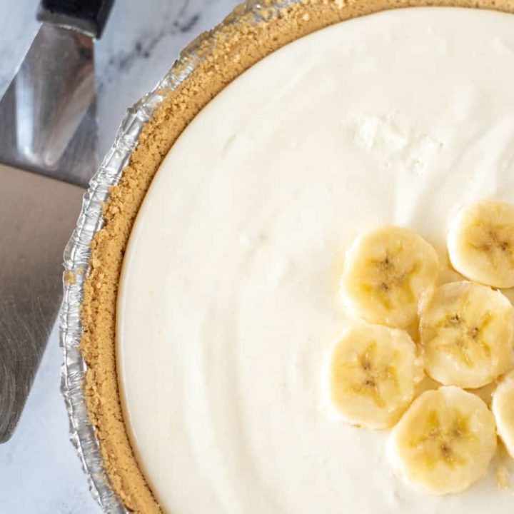 sqaure overhead image of whole banana pudding pie with sliced bananas