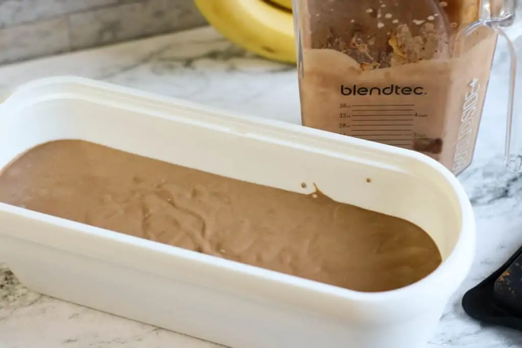 dairy free chocolate peanut butter ice cream mixture in freezer container and blender