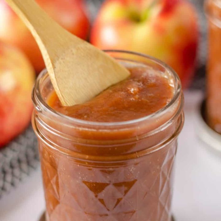 jar of instant pot apple butter with wooden spoon
