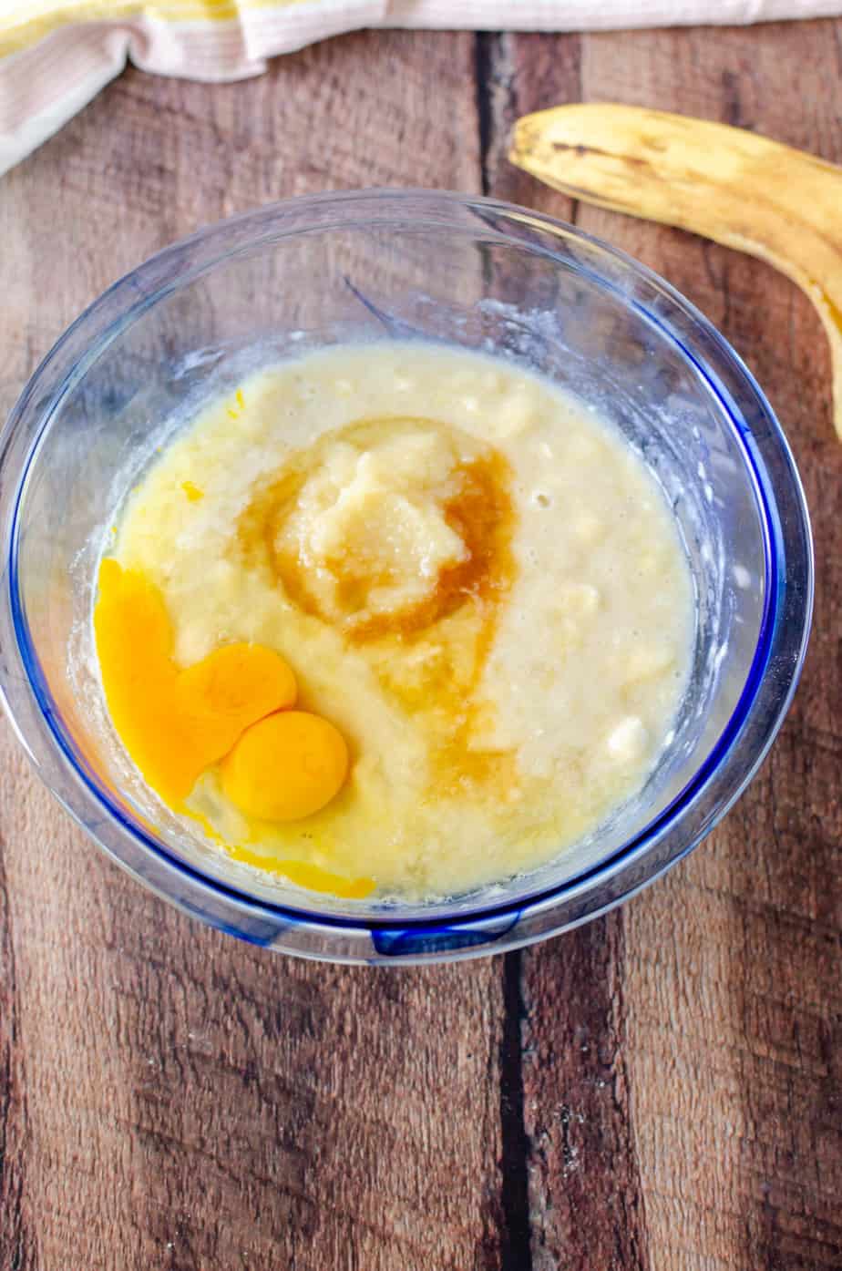 mashed bananas, vanilla, applesauce, and sugar in a glass bowl