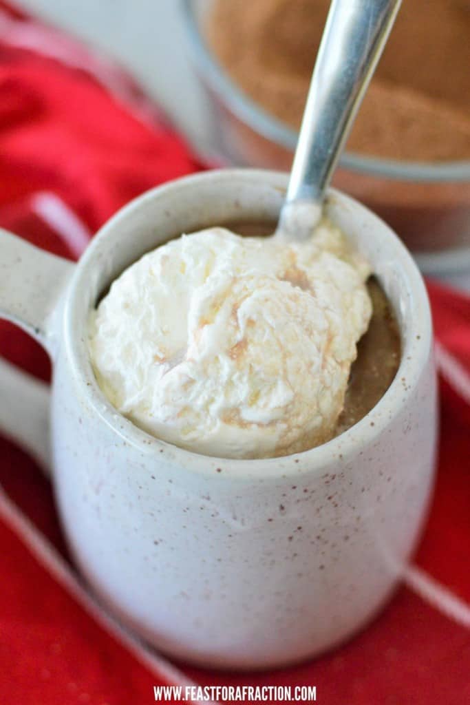 hot chocolate in grey mug topped with whipped cream
