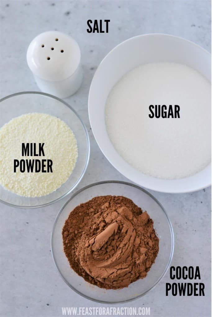 sugar, cocoa powder, milk powder and salt in bowls on counter