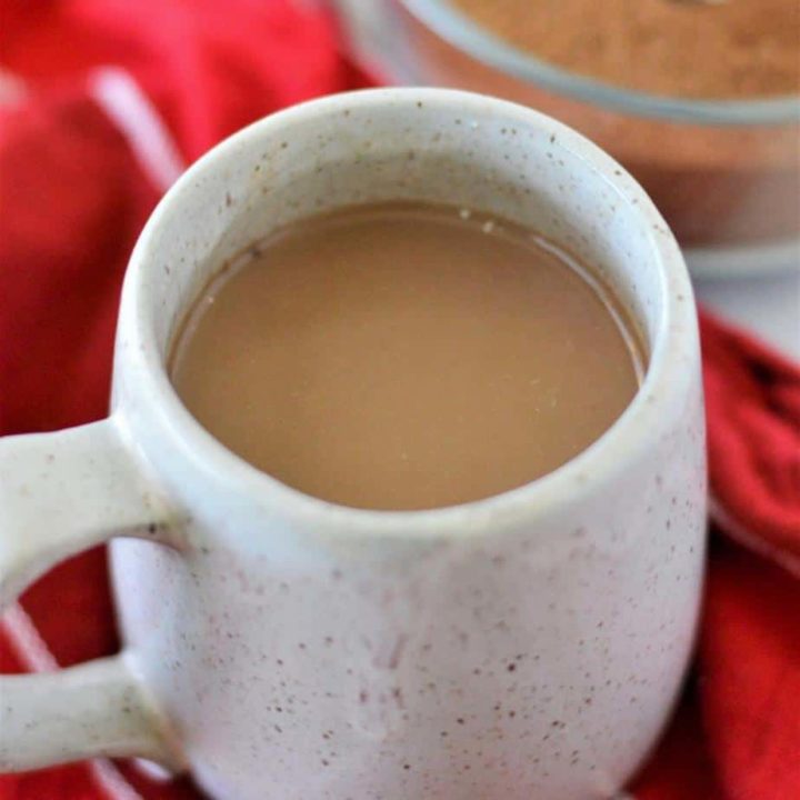 square image of hot chocolate in a gray mug with red napkin