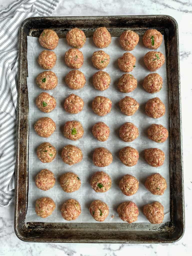 formed meatballs on sheet pan lined with parchment paper