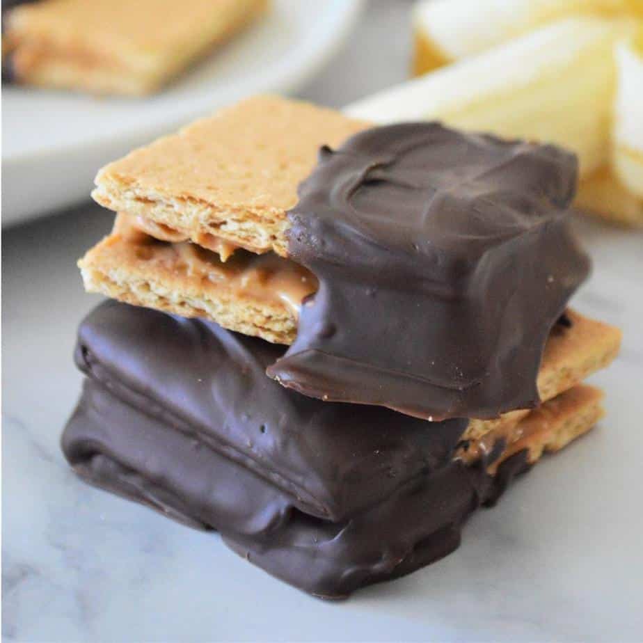 square image of graham crackers sandwiched with peanut butter and banana dipped in chocolate