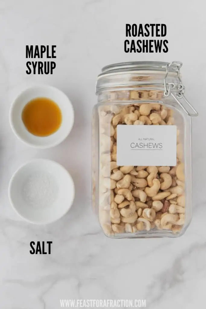 roasted cashews in glass jar with bowls of maple syrup and salt