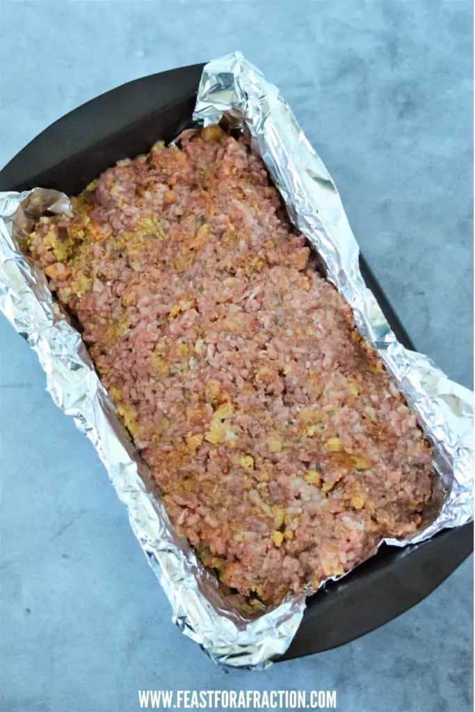 stovetop stuffing meatloaf mixture in loaf pan lined with aluminum foil