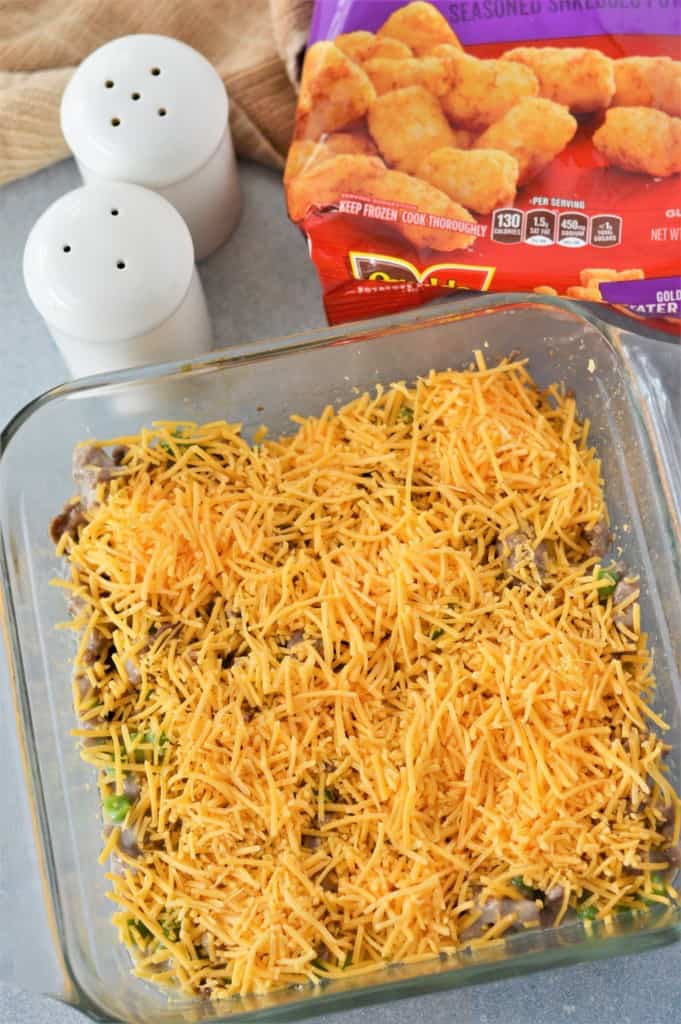 shredded cheese sprinkled on tater tot casserole filling