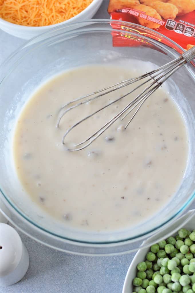 cream of mushroom soup in glass bowl with whisk