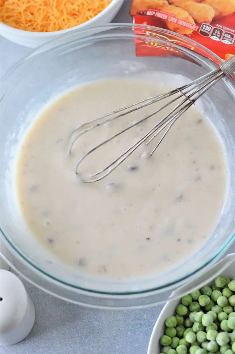 cream of mushroom soup in glass bowl with whisk