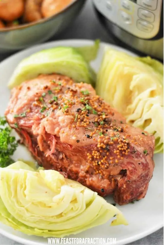 corned beef and cabbage on white plate garnished with parsley and instant pot in background