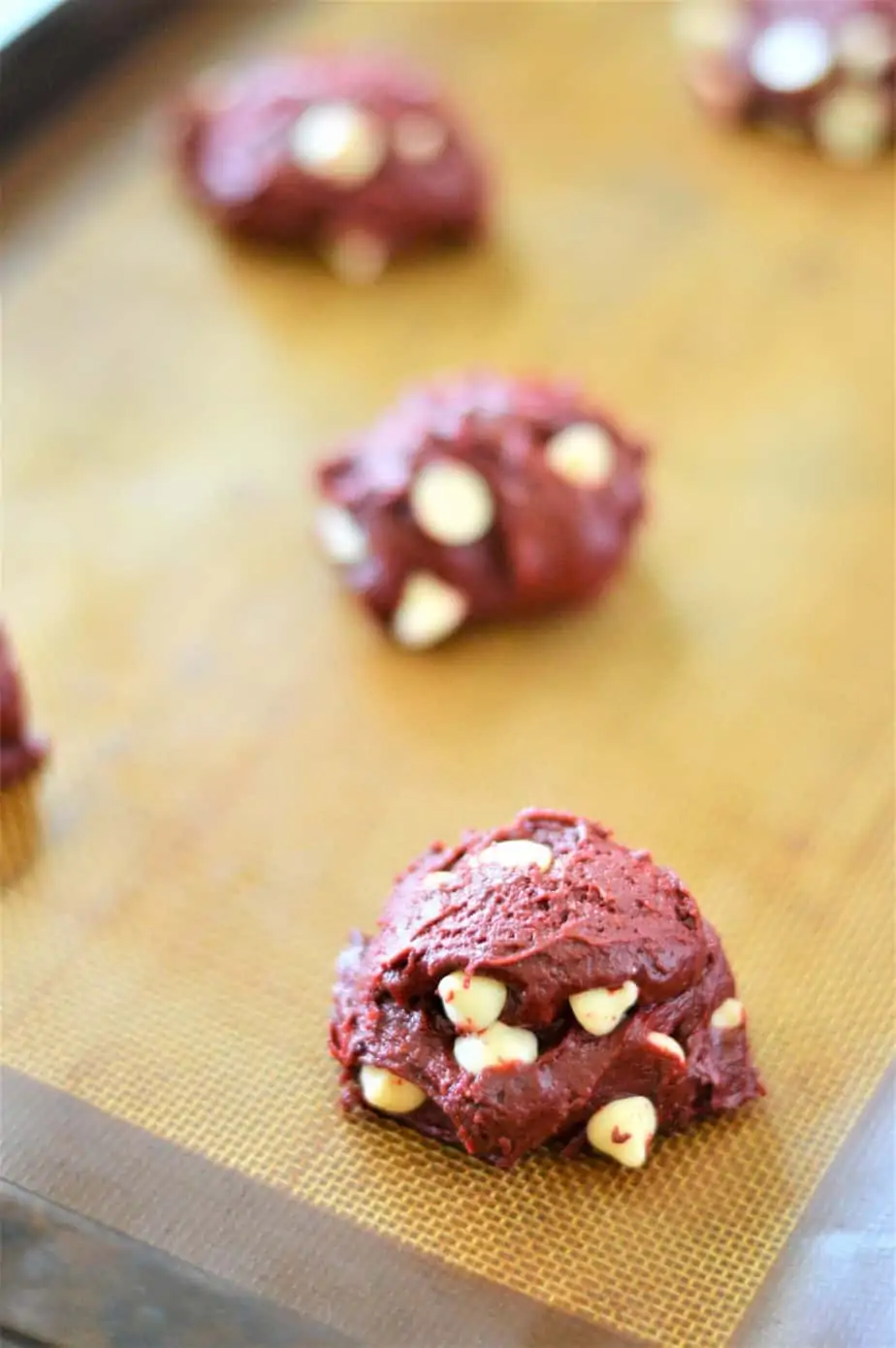 red velvet cake mix cookie dough scooped into balls on baking sheet